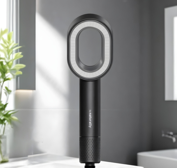 Black handheld showerhead with circular design on a bathroom counter
